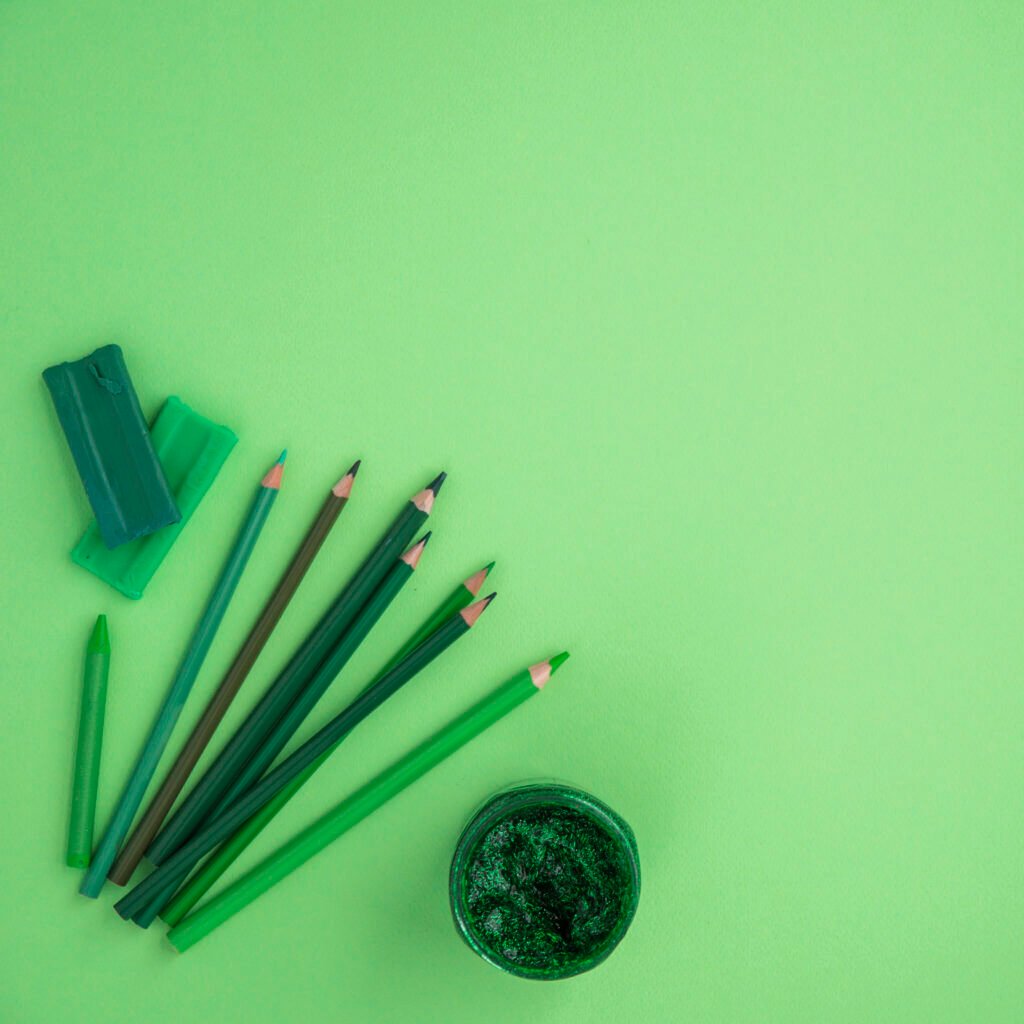 high-angle-view-color-pencils-crayon-clay-glitter-color-green-backdrop
